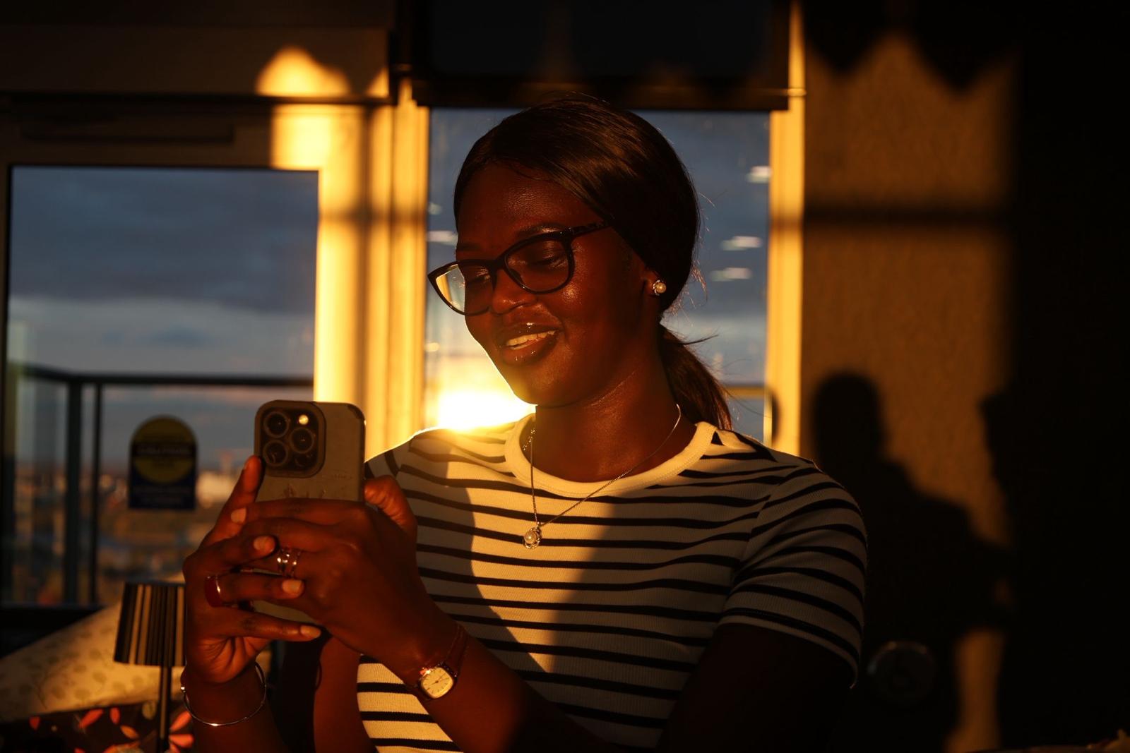 Smiling youth participant taking a photo in warm evening light.