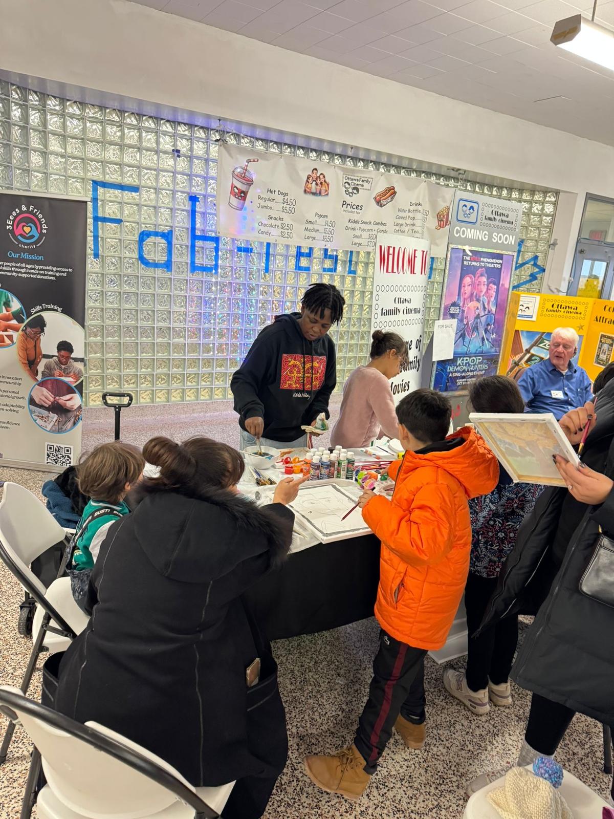 Children and youth painting at an Empower Youth Canada community booth.
